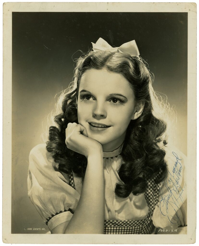 An impressive vintage photo of Garland as Dorothy Gale clad in her white blouse and gingham dress for the 1939 film, The Wizard of Oz.