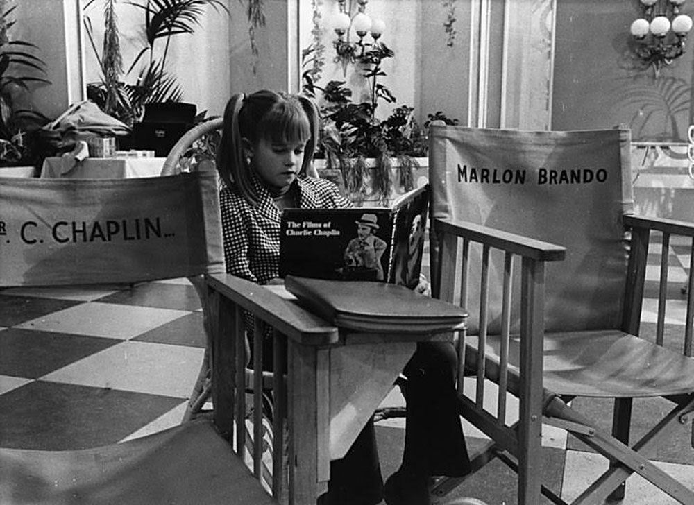 Ten-year-old Melanie Griffith reading a book about Chaplin's films while sitting next to Chaplin's director's chair. Griffith's mother, Tippi Hedren, also starred in the film as Martha Mears, the wife of Marlon Brando's character, Ogden Mears.