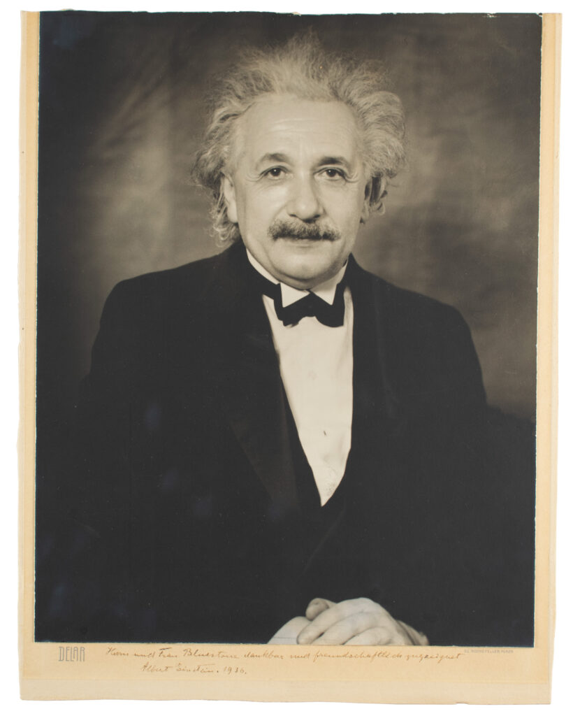Albert Einstein suited up while wearing a cheeky smirk.
