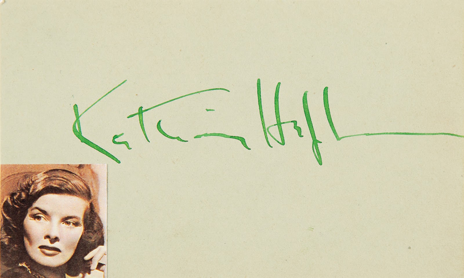 Autograph of golden age Hollywood actress Katharine Hepburn, with her photo affixed to the lower left corner.