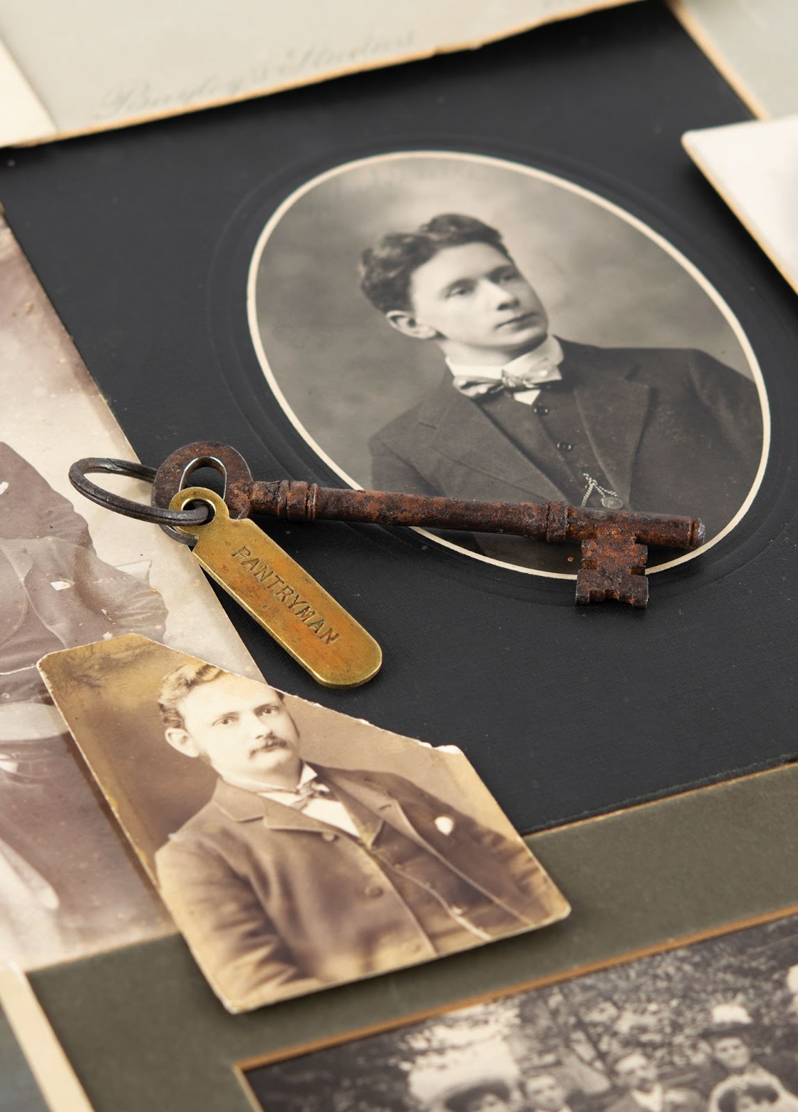 The “Pantryman” key found on the body of Titanic saloon steward Alfred Arnold Deeble, accompanied by early 20th-century photographs of him.