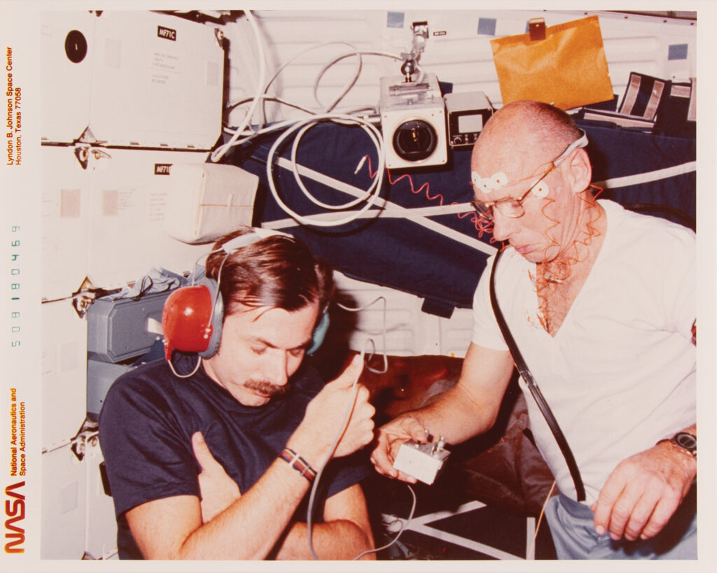 NASA astronaut William E. Thornton conducting a biomedical experiment aboard Challenger on STS-8